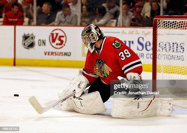 Cristobal Huet of the Chicago Blackhawks knocks the puck away against the Vancouver Canucks in Game One of the Western Conference Semifinals during...