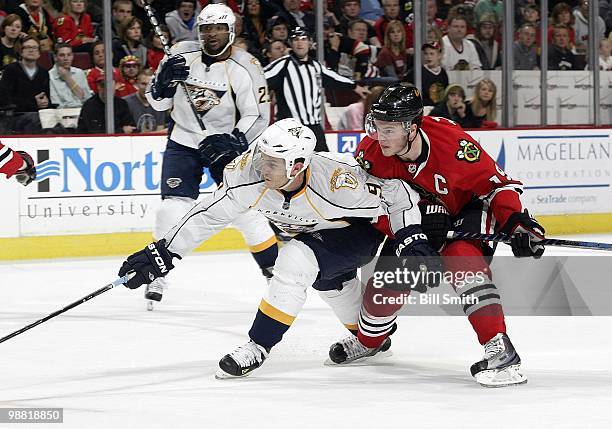 Marcel Goc of the Nashville Predators reaches for the puck as Jonathan Toews of the Chicago Blackhawks follows behind at Game Two of the Western...