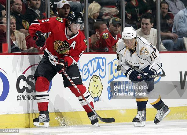 Duncan Keith of the Chicago Blackhawks and Martin Erat of the Nashville Predators keep their eyes on the puck at Game Two of the Western Conference...