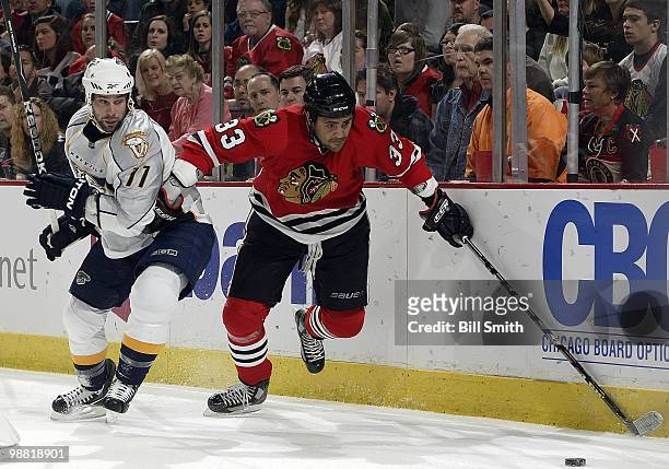 Dustin Byfuglien of the Chicago Blackhawks pushes off of David Legwand of the Nashville Predators as he chases the puck up the boards at Game Two of...