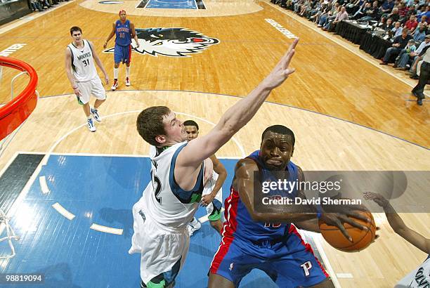 Will Bynum of the Detroit Pistons goes up for a layup against Kevin Love of the Minnesota Timberwolves during the game at Target Center on April 14,...