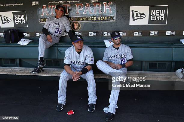 Pitching coach Bob Apodaca, Miguel Olivo and Ryan Spilborghs of the Colorado Rockies get ready in the dugout before the game between the Colorado...