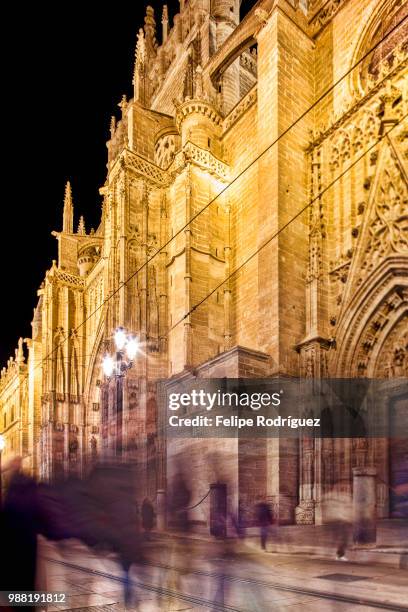 pedestrians on constitution avenue, in front of the cathedral, seville, spain - constitution avenue stock pictures, royalty-free photos & images