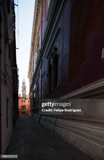 the bell tower of san pantalon church at the end of a narrow sreet, venice, italy - pantalon stock pictures, royalty-free photos & images