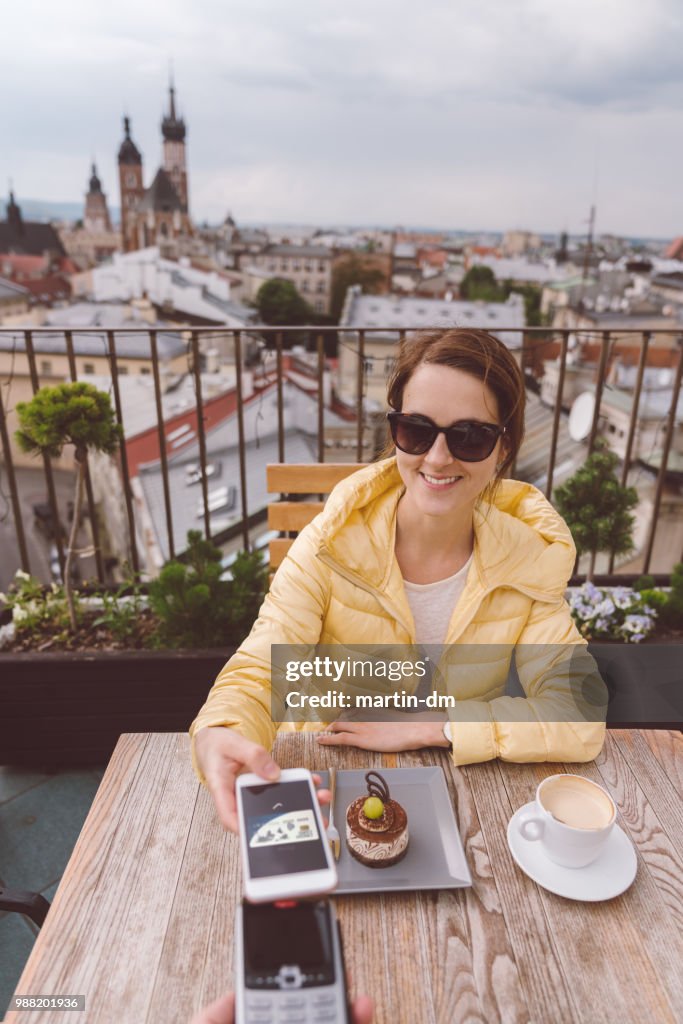Woman in Krakow old town using digital wallet for mobile payment