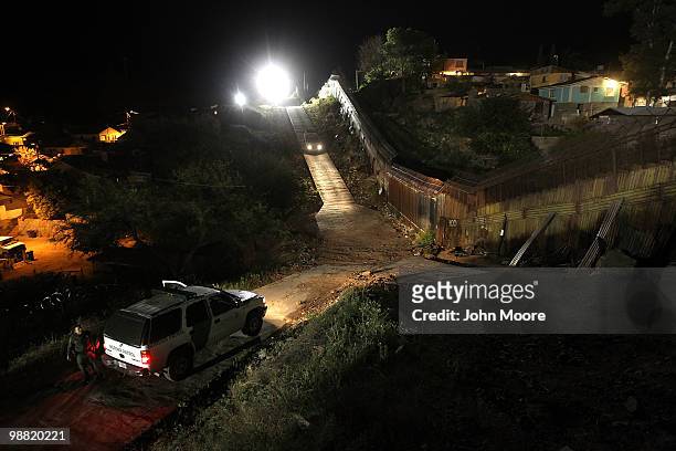 Border Patrol vehicles move near the border fence between the United States and Mexico on May 2, 2010 in Nogales, Arizona. Although the U.S....
