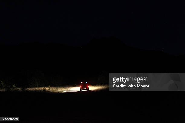 Border Patrol vehicle shines a spotlight along a roadside next to the border between the United States and Mexico on May 2, 2010 at Montezuma Pass,...