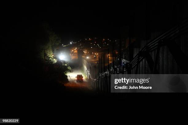 Border Patrol vehicle moves along the border fence between the United States and Mexico on May 2, 2010 in Nogales, Arizona. Although the U.S....