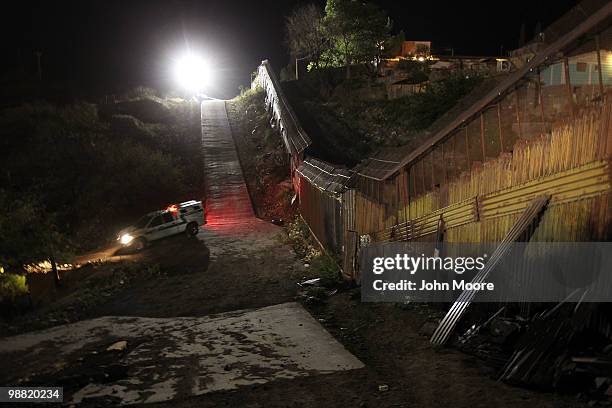 Border Patrol vehicle moves near the border fence between the United States and Mexico on May 2, 2010 in Nogales, Arizona. Although the U.S....