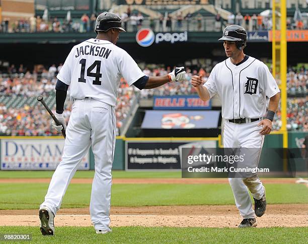 Austin Jackson and Scott Sizemore of the Detroit Tigers bump fists against the Los Angeles Angels of Anaheim during the game at Comerica Park on May...