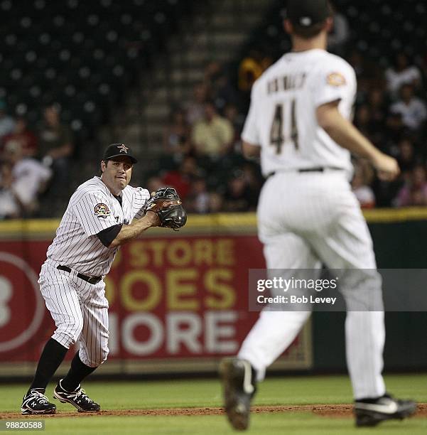 First baseman Lance Berkman of the Houston Astros prepares to throw to pitcher Roy Oswalt covering first base against the Cincinnati Reds at Minute...