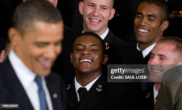 Quarterback Ricky Dobbs of the US Naval Academy football team laughs as US President Barack Obama jokes about him during a ceremony where Obama...