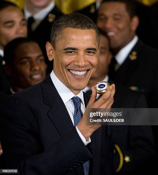 President Barack Obama holds a US Naval Academy team ring during a ceremony where Obama presents the Commander in Chief trophy to the team in the...