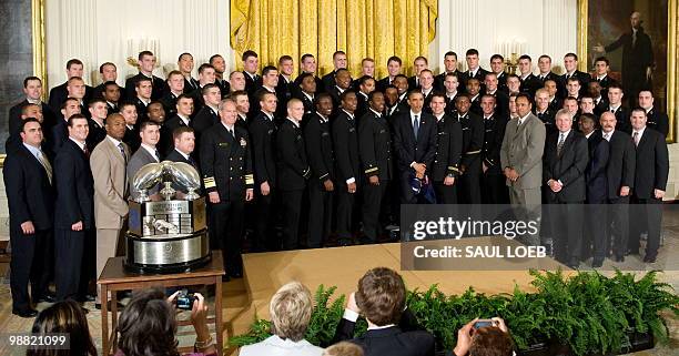 President Barack Obama poses for photos alongside members of the US Naval Academy football team during a ceremony where Obama presents the Commander...