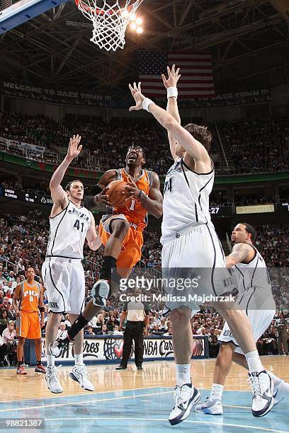 Amare Stoudemire of the Phoenix Suns takes the ball to the basket against Kosta Koufos and Mehmet Okur of the Utah Jazz during the game at...