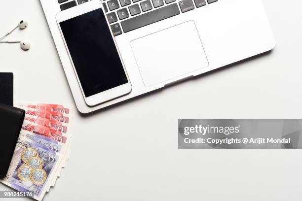 gbp british sterling notes with mobile phone, laptop, wallet on office desk with copy space - bringing home the bacon engelse uitdrukking stockfoto's en -beelden