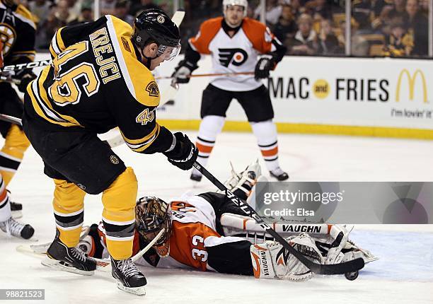 David Krejci of the Boston Bruins gets the puck past Brian Boucher of the Philadelphia Flyers to score in the third period in Game One of the Eastern...