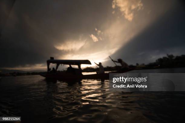 a silhoutte of a shikara boat - shikara stockfoto's en -beelden