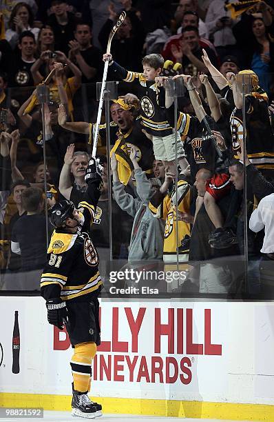 Marc Savard of the Boston Bruins hands his stick off to a fan after the game against the Philadelphia Flyers in Game One of the Eastern Conference...