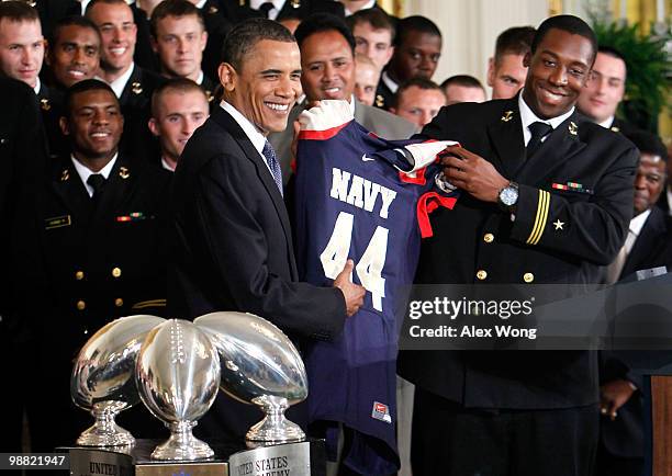 President Barack Obama receives a jersey from Osei Asante of the Navy football team Midshipmen during the presentation ceremony of the...