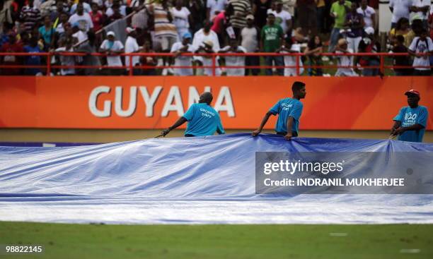 Groundstaff remove covers from the ground during the rain-curtailed England v/s West Indies ICC World Twenty20 2010 match at the Providence Stadium...