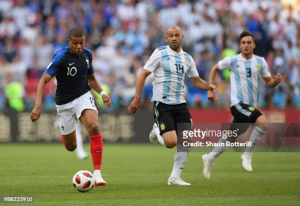Kylian Mbappe of France breaks away from Javier Mascherano of Argentina during the 2018 FIFA World Cup Russia Round of 16 match between France and...