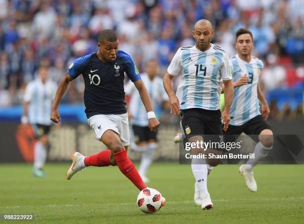 Kylian Mbappe of France breaks away from Javier Mascherano of Argentina during the 2018 FIFA World Cup Russia Round of 16 match between France and...