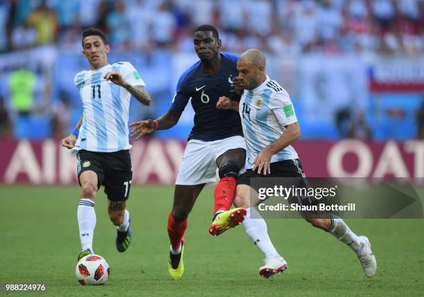 Paul Pogba of France is challenged by Angel Di Maria and Javier Mascherano of Argentina during the 2018 FIFA World Cup Russia Round of 16 match...