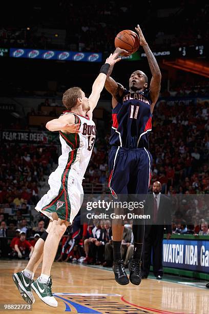 Jamal Crawford of the Atlanta Hawks shoots over Luke Ridnour of the Milwaukee Bucks in Game Six of the Eastern Conference Quarterfinals during the...