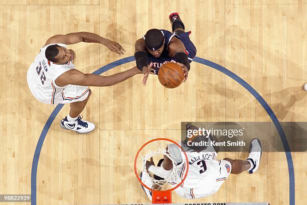 Josh Smith of the Atlanta Hawks rebounds the ball against Boris Diaw and Gerald Wallace of the Charlotte Bobcats during the game on April 6, 2010 at...