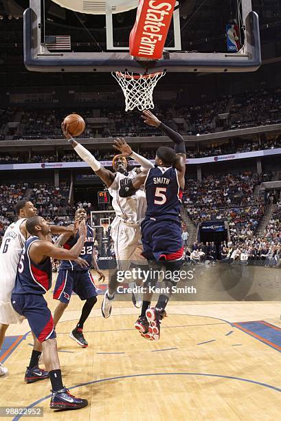 Gerald Wallace of the Charlotte Bobcats puts the ball up against Josh Smith of the Atlanta Hawks during the game on April 6, 2010 at the Time Warner...