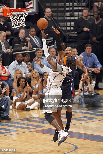 Gerald Wallace of the Charlotte Bobcats puts a shot up against Maurice Evans of the Atlanta Hawks during the game on April 6, 2010 at the Time Warner...