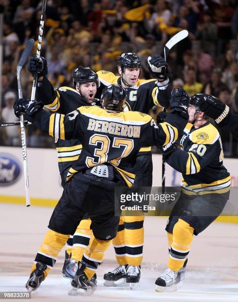 Johnny Boychuk of the Boston Bruins is congratulated by teammates Zdeno Chara, Patrice Bergeron and Daniel Paille after Boychuk scored in the first...
