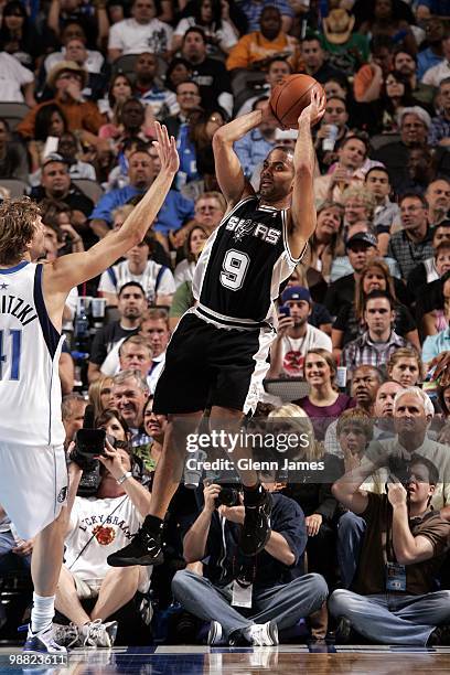 Tony Parker of the San Antonio Spurs passes against Dirk Nowitzki of the Dallas Mavericks during the game at American Airlines Center on April 14,...