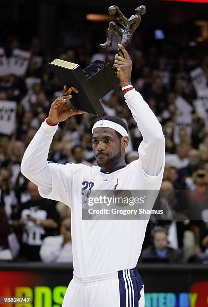 LeBron James of the Cleveland Cavaliers holds up the Maurice Podoloff Trophy after being named the 2009-2010 NBA MVP prior to playing the Boston...