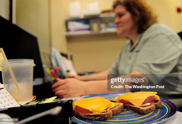 Brenda Middleton eats a tomato and cheese sandwich at her desk at the Alphagraphics store in Alexandria, VA on April 28, 2010. Like most small...