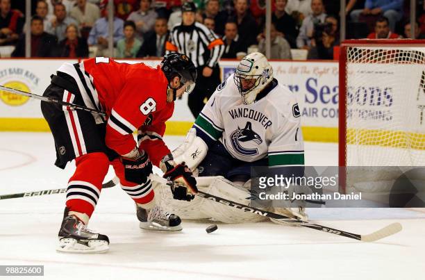 Tomas Kopecky of the Chicago Blackhawks tries to get off a shot against Roberto Luongo of the Vancouver Canucks in Game Two of the Western Conference...