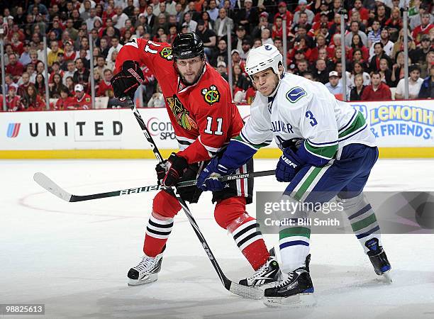 John Madden of the Chicago Blackhawks and Kevin Bieska of the Vancouver Canucks wait in position for the puck at Game Two of the Western Conference...