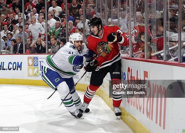 Andrew Alberts of the Vancouver Canucks pushes into Dave Bolland of the Chicago Blackhawks at Game Two of the Western Conference Semifinals during...