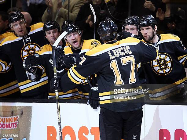 Milan Lucic of the Boston Bruins is congratulated by teammates on the bench after he scored the game winning goal in the first period against the...