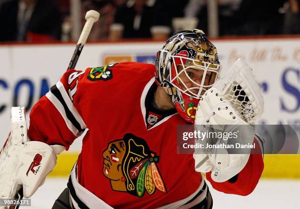 Antti Niemi of the Chicago Blackhawks looks at the puck in his glove after a save against the Vancouver Canucks in Game Two of the Western Conference...