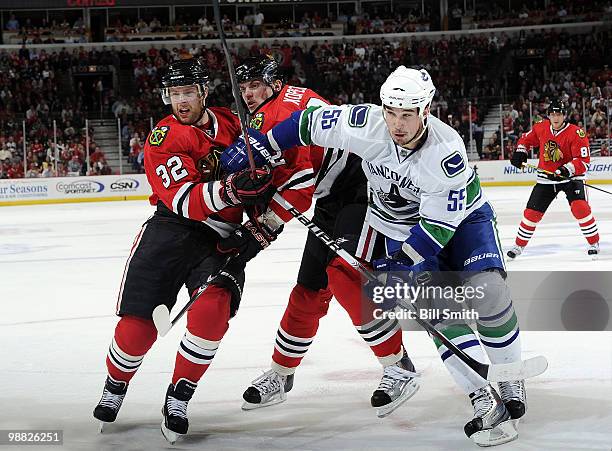 Shane O'Brien of the Vancouver Canucks skates past Kris Versteeg and Tomas Kopecky of the Chicago Blackhawks, at Game Two of the Western Conference...