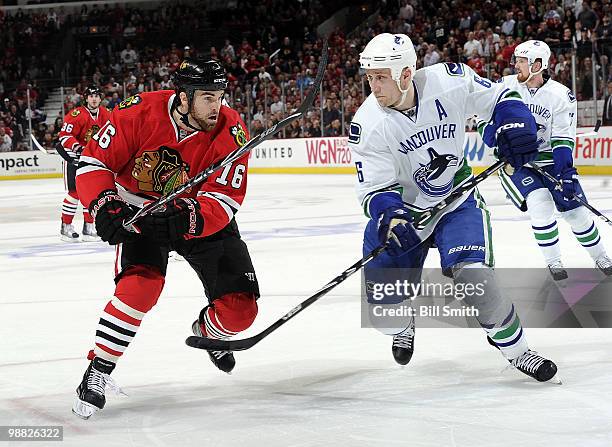 Andrew Ladd of the Chicago Blackhawks and Sami Salo of the Vancouver Canucks skate toward the puck at Game Two of the Western Conference Semifinals...