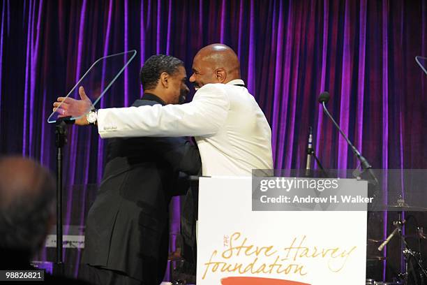 Actor Denzel Washington and host Steve Harvey embrace on stage during the New York Gala benefiting The Steve Harvey Foundation at Cipriani, Wall...