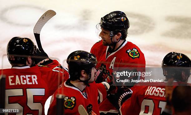 Patrick Sharp of the Chicago Blackhawks is congratulated by teammates including Ben Eager, Dave Bolland and Marian Hossa after scoring a 3rd period...