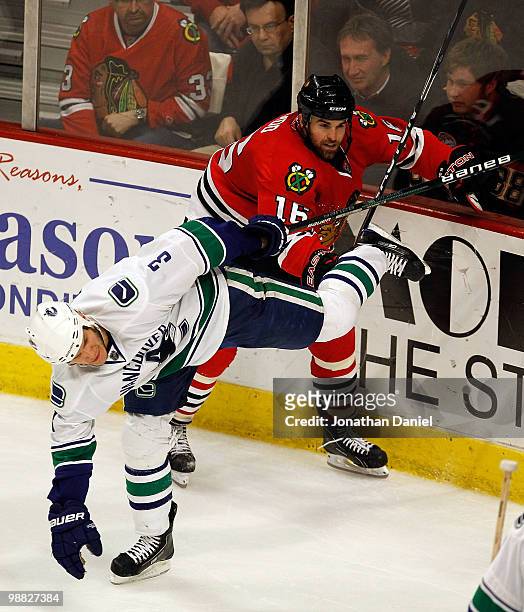 Andrew Ladd of the Chicago Blackhawks and Kevin Bieksa of the Vancouver Canucks get tangled up along the boards in Game Two of the Western Conference...