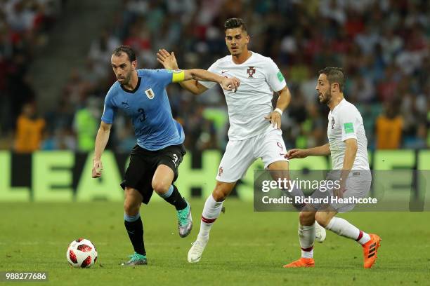 Diego Godin of Uruguay is challenged by Andre Silva and Bernardo Silva of Portugal during the 2018 FIFA World Cup Russia Round of 16 match between...