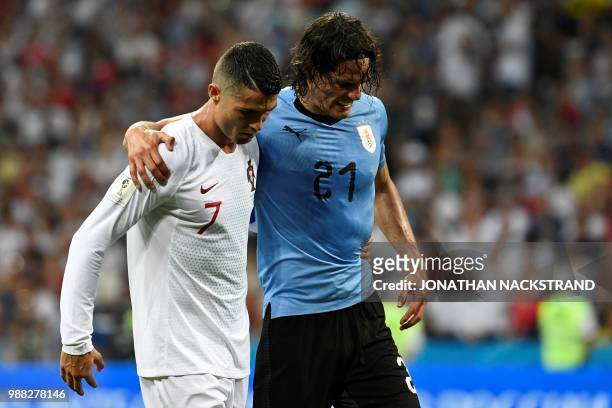 Uruguay's forward Edinson Cavani leaves the pitch comforted by Portugal's forward Cristiano Ronaldo during the Russia 2018 World Cup round of 16...