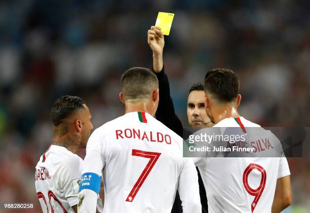 Cristiano Ronaldo of Portugal is shown a yellow card by referee Cesar Ramos during the 2018 FIFA World Cup Russia Round of 16 match between Uruguay...