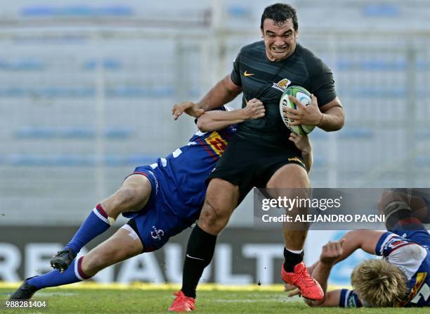 Argentina's Jaguares hooker Agustin Creevy is tackled by South Africa's Stormers centre Justin Phillips during their Super Rugby match at Jose...